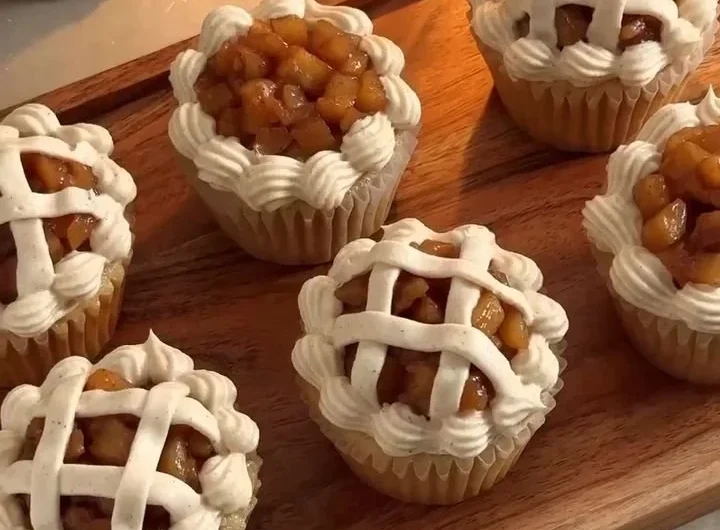 Delicious apple pie cupcakes topped with cream and apple slices