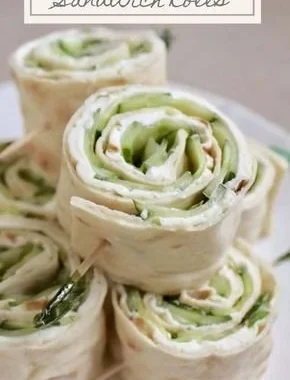 Cucumber and cream cheese sandwich rolls on a platter