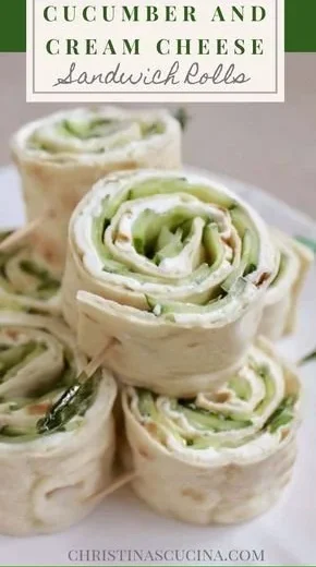 Cucumber and cream cheese sandwich rolls on a platter