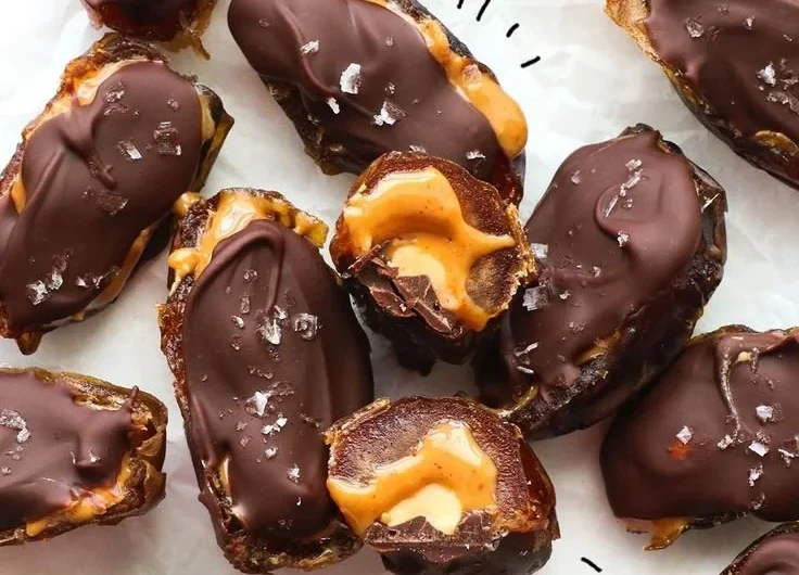 A plate of homemade Date Snickers bars, a healthy dessert alternative.