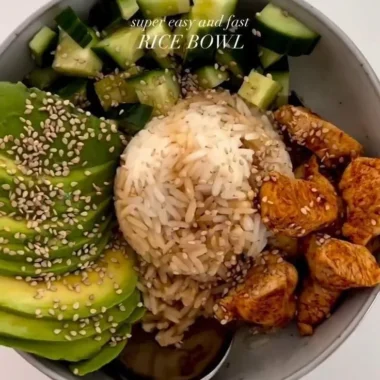 Delicious healthy chicken and rice bowl topped with fresh vegetables