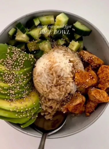 Delicious healthy chicken and rice bowl topped with fresh vegetables