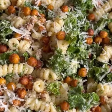 A vibrant Kale Caesar Pasta Salad with greens, pasta, and creamy dressing served in a bowl.