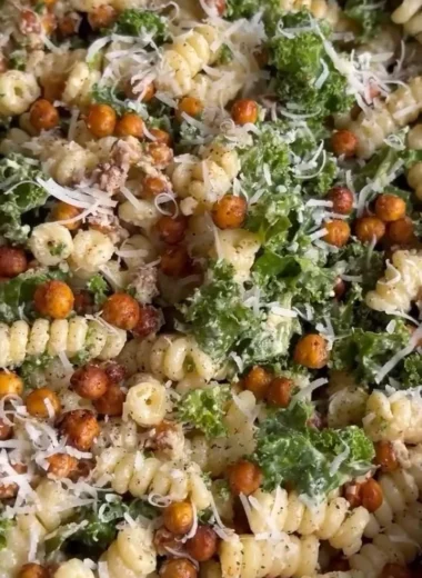 A vibrant Kale Caesar Pasta Salad with greens, pasta, and creamy dressing served in a bowl.