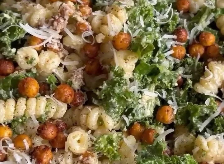 A vibrant Kale Caesar Pasta Salad with greens, pasta, and creamy dressing served in a bowl.