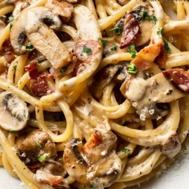 Delicious plate of Bacon and Mushroom Pasta with creamy sauce and fresh herbs