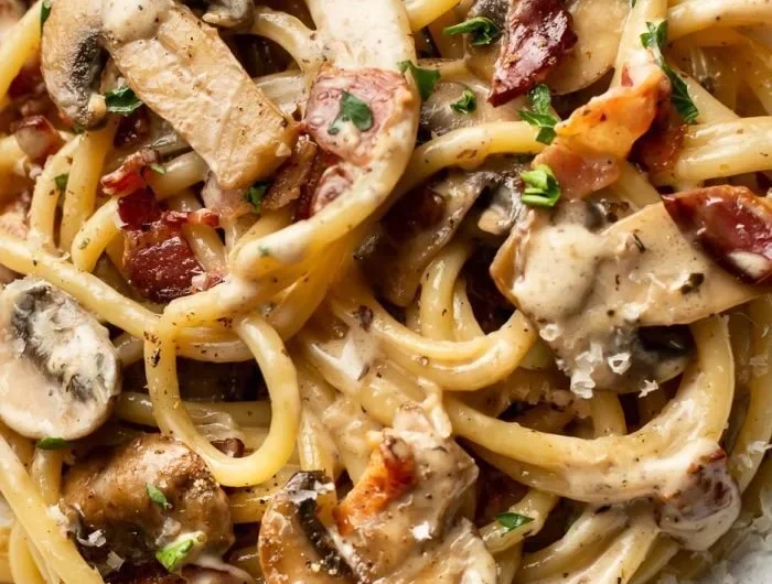 Delicious plate of Bacon and Mushroom Pasta with creamy sauce and fresh herbs