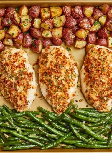 Parmesan Crusted Chicken on a sheet pan with vegetables and herbs