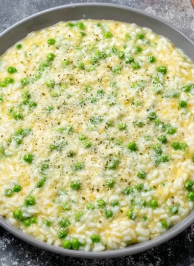 A plate of Rice and Peas served with fresh herbs and spices, showcasing its vibrant colors.