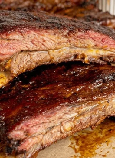Smoky tender beef ribs on a barbecue grill, ready to serve.
