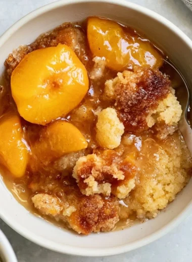 Delicious Southern peach cobbler dessert served warm with ice cream