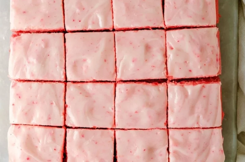 Delicious strawberry brownies topped with creamy frosting on a plate