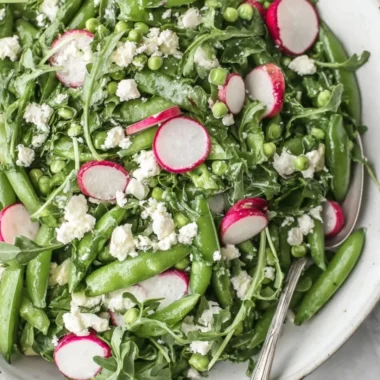 Vibrant Sugar Snap Pea Salad topped with fresh vegetables and dressing