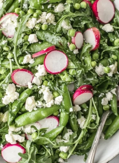 Vibrant Sugar Snap Pea Salad topped with fresh vegetables and dressing