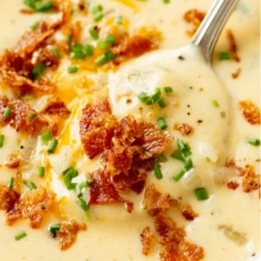 Delicious bowl of creamy baked potato soup topped with cheese and chives