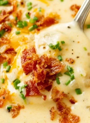 Delicious bowl of creamy baked potato soup topped with cheese and chives
