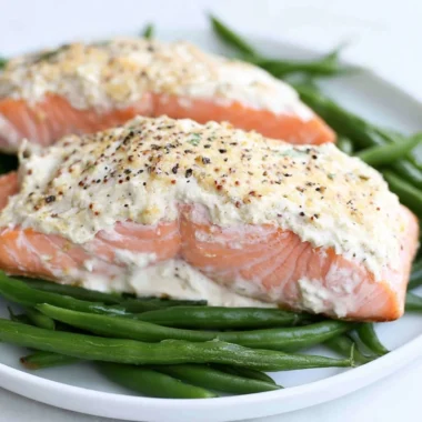 Baked salmon with a delicious sour cream crust, garnished and plated for serving.