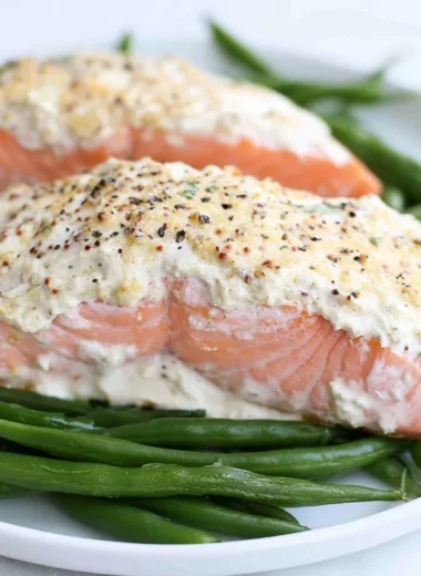 Baked salmon with a delicious sour cream crust, garnished and plated for serving.