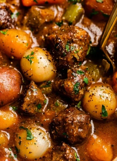Delicious beef stew simmering in a pot with fresh vegetables and herbs