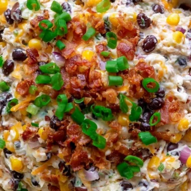 Delicious cowboy corn dip served in a bowl, garnished with fresh herbs.