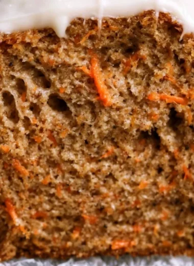Cozy carrot cake loaf served on a rustic plate with frosting and decorative carrots