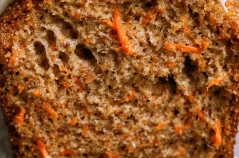 Cozy carrot cake loaf served on a rustic plate with frosting and decorative carrots