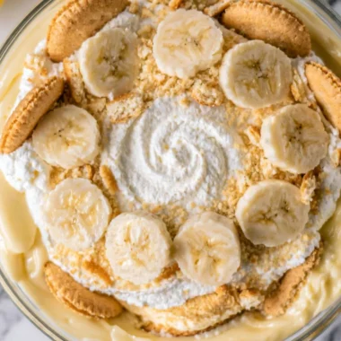 Delicious cozy homemade banana pudding in a glass bowl with whipped cream topping