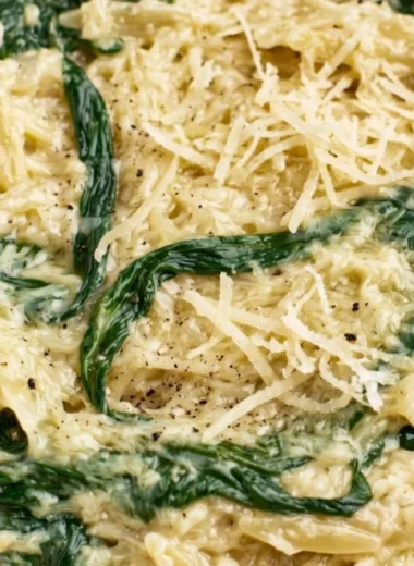 Creamy garlic spinach orzo dish served in a bowl, garnished with parsley.