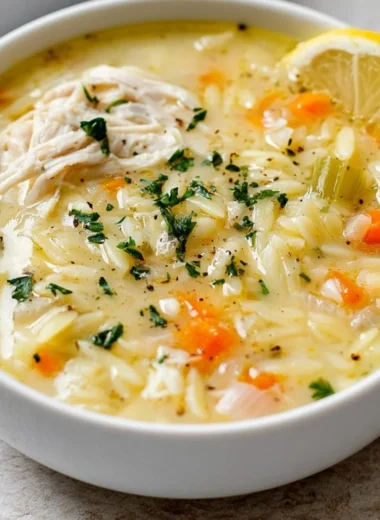 Delicious easy lemon chicken orzo soup in a bowl garnished with herbs