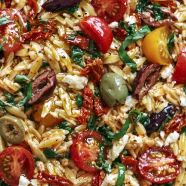 Greek Orzo salad with tomatoes, olives, basil, and feta cheese.