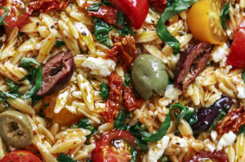Greek Orzo salad with tomatoes, olives, basil, and feta cheese.