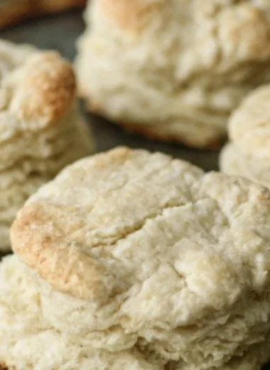 Freshly baked homemade buttery biscuits on a wooden table.
