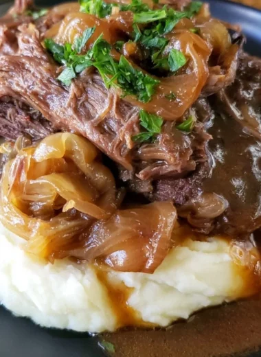Melt in your mouth pot roast served with vegetables in a rustic dish.
