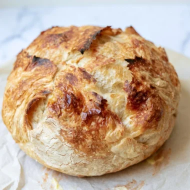 Freshly baked warm sourdough croissant displaying golden flaky layers