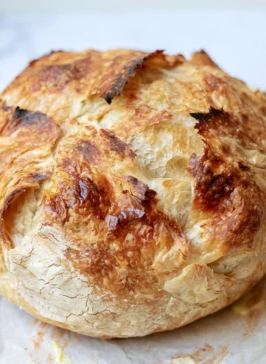 Freshly baked warm sourdough croissant displaying golden flaky layers