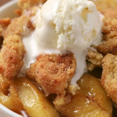 Homemade apple cobbler topped with golden crust and served in a baking dish