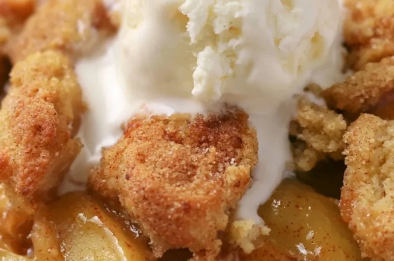Homemade apple cobbler topped with golden crust and served in a baking dish