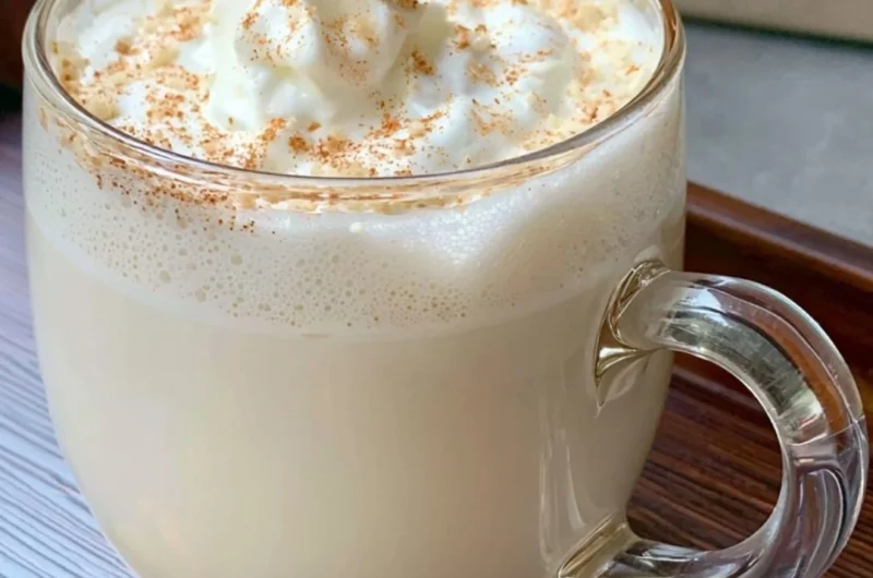 A creamy Vanilla Almond Snowflake Latte topped with whipped cream and snowflake sprinkles